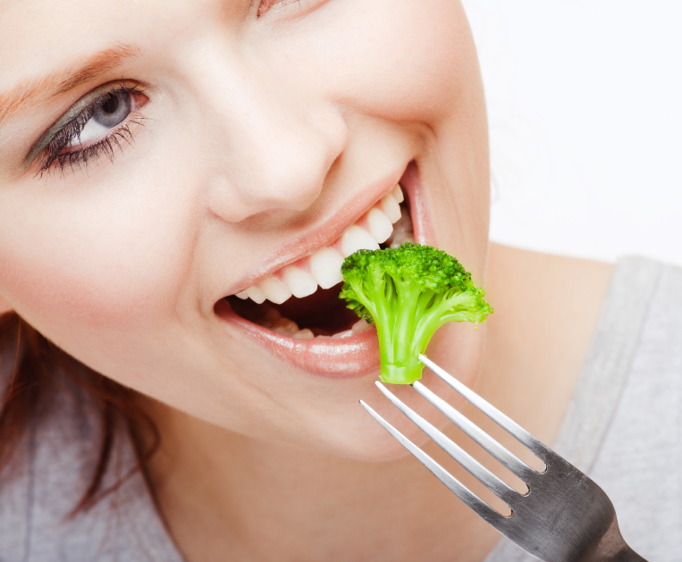 Kvinna äter broccoli